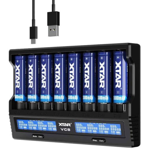XTAR VC8 8-channel charger with LCD showing voltage for Li-ion batteries in a home office setup.