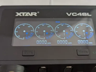 XTAR VC4SL charger with 18650 batteries for flashlight use in outdoor security patrols.