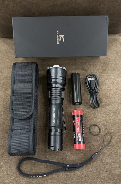 Klarus XT12GT PRO flashlight illuminating a dark trail during nighttime hiking for extended visibility.